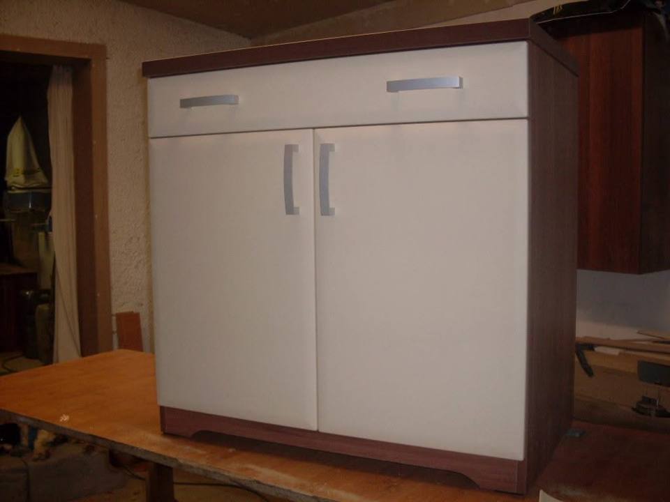 Weißer Schrank mit Lade und dunkler Platte in der Werkstatt
