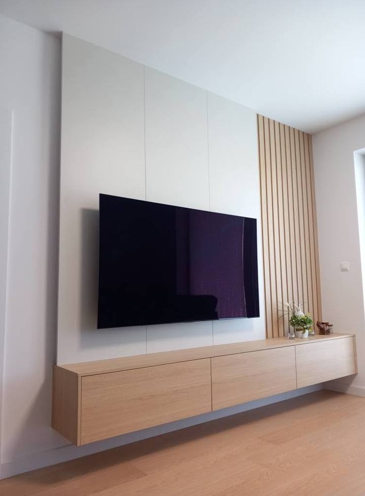 Frontansicht der weißen TV-Wand mit Lamellen in Eichenoptik