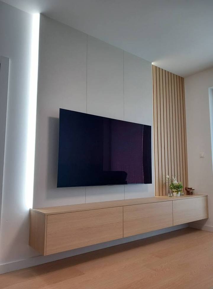 Weiße TV-Wand mit LED-Band, Lamellen und Hängeelement