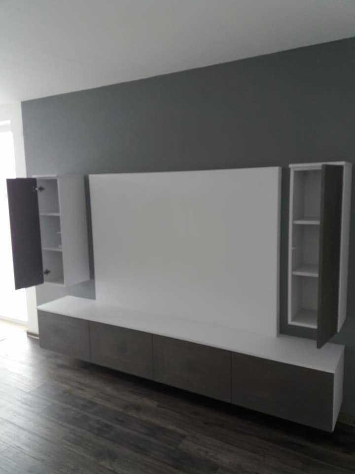 TV-Wand mit geöffneten hohen Kästen und Fachböden im Inneren