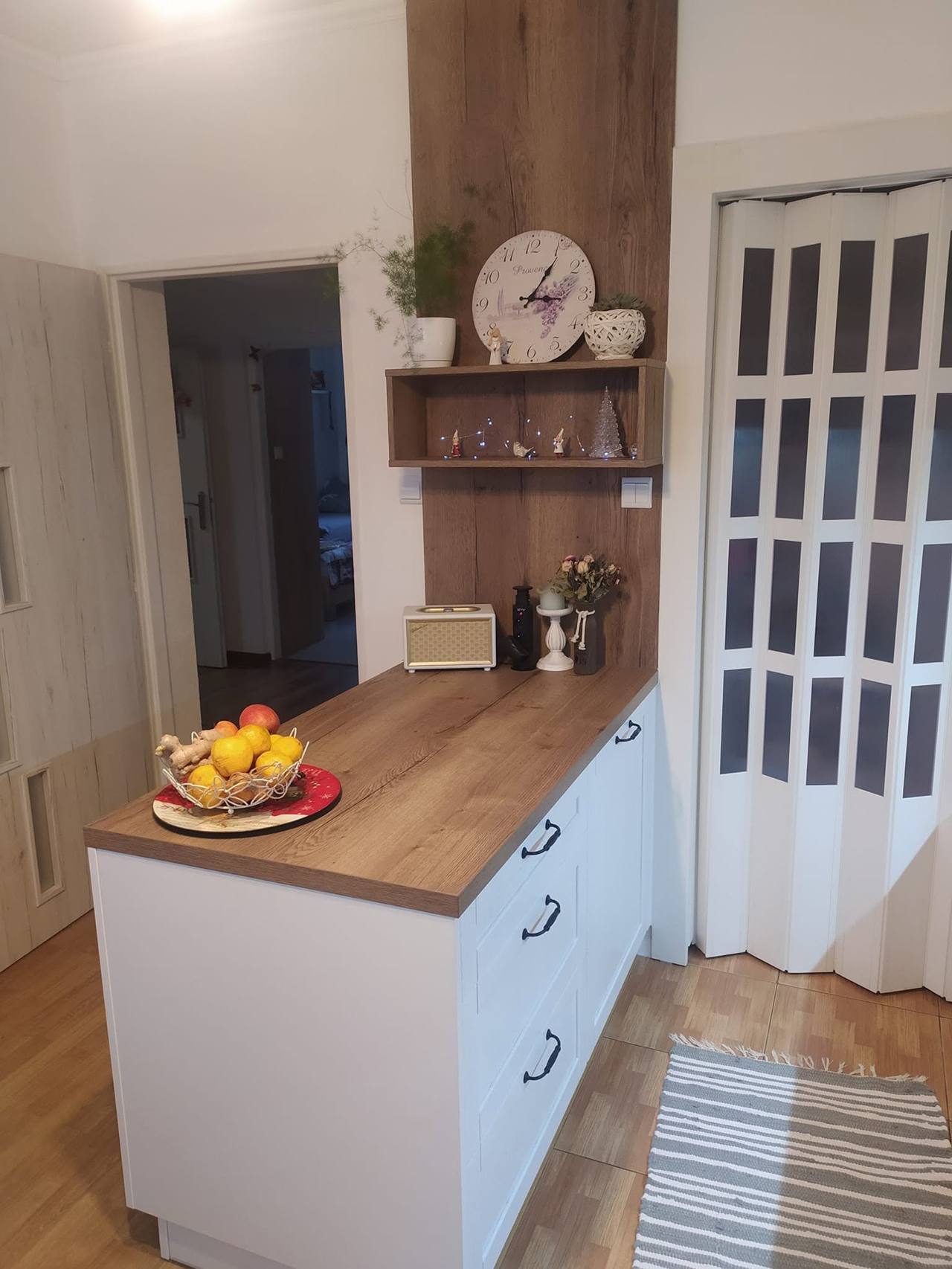 Weiße Kochinsel mit Eichendekor-Platte und Obstschale