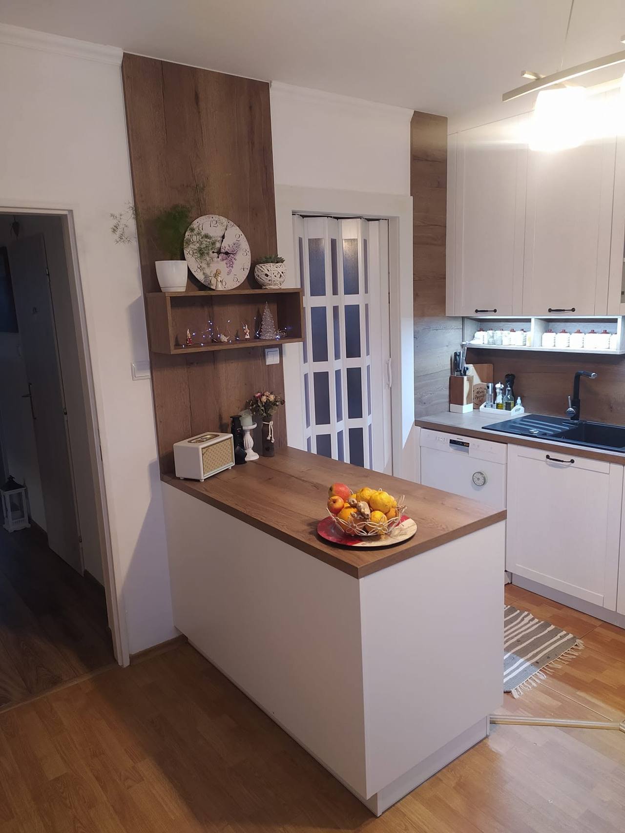 Weiße Landhausküche mit offenem Regal und Kochinsel