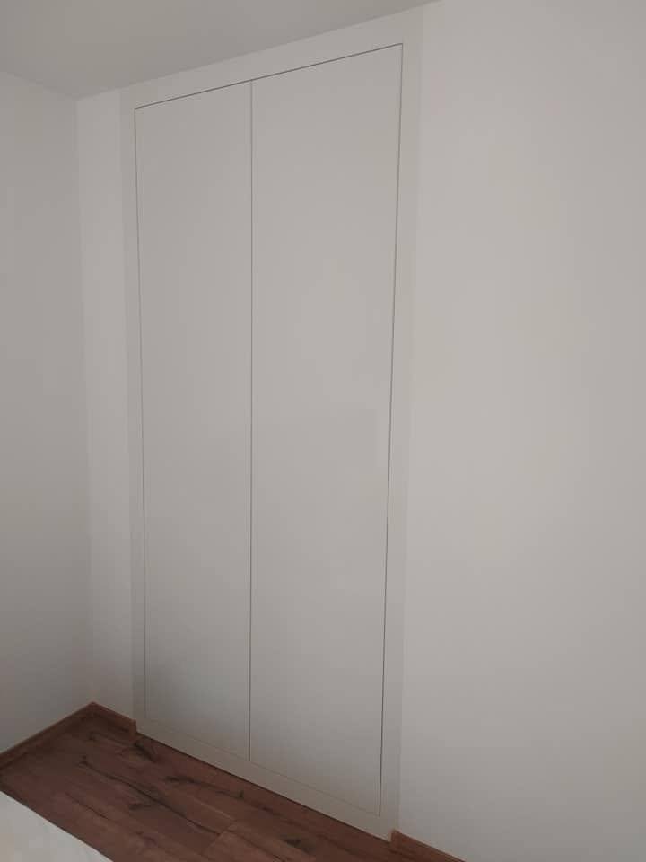 Weißer Einbaukasten ohne Griffe im leeren Zimmer