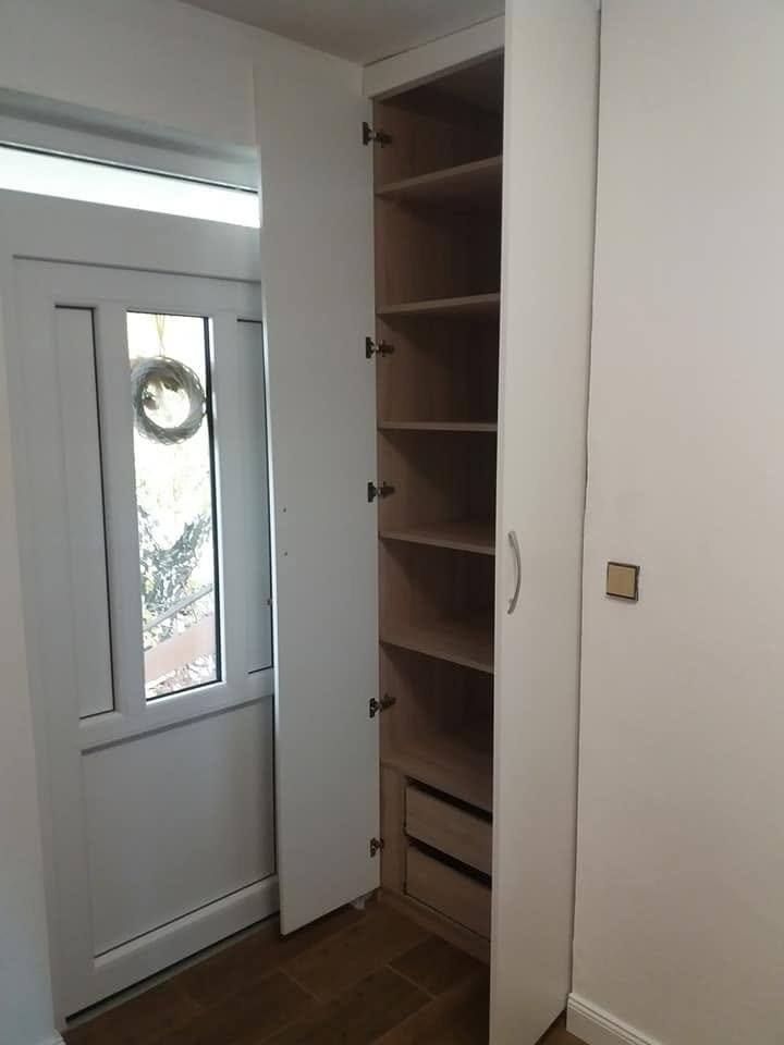 Geöffnete Kastentür mit Fachböden in Holzdekor und Laden