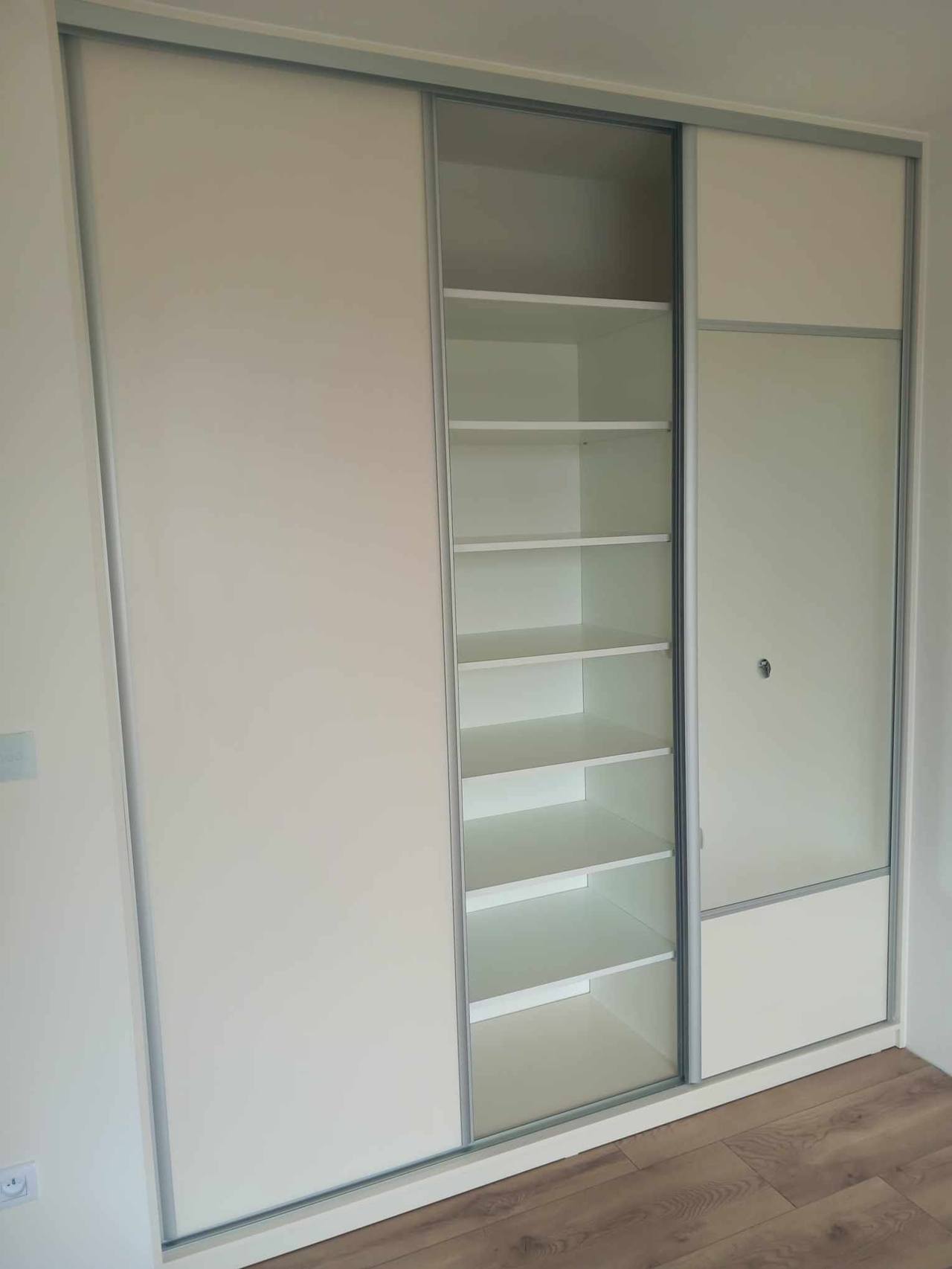 Weißer Kasten mit offenen Fachböden und grauem Glas in der Mitte