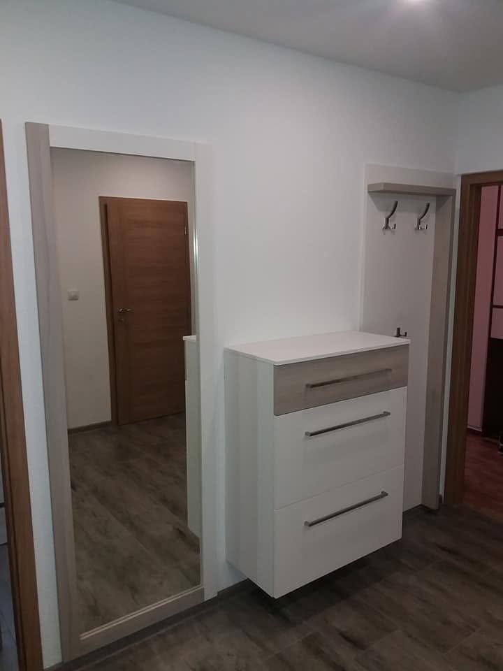 Weiße Ladenkommode, Garderobenpaneel und Spiegel im Vorzimmer