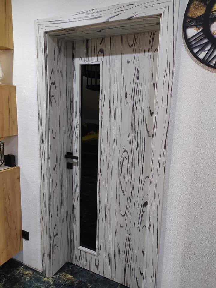 Tür mit kräftiger schwarzer Jahresring-Zeichnung und schmalem Glas