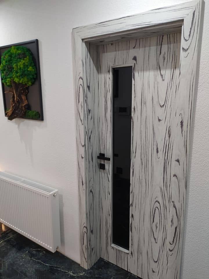 Tür mit Jahresring-Dekor und senkrechtem schwarzem Glas im Flur