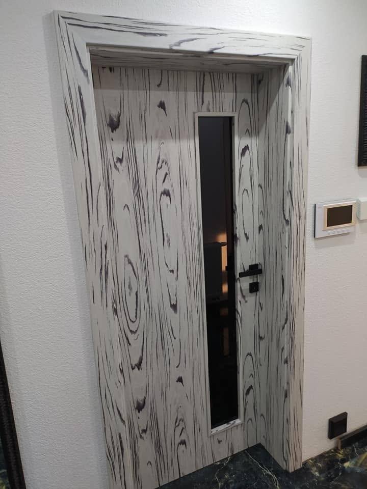Innentür mit schwarz-weißer Holzmaserung und schwarzer Klinke