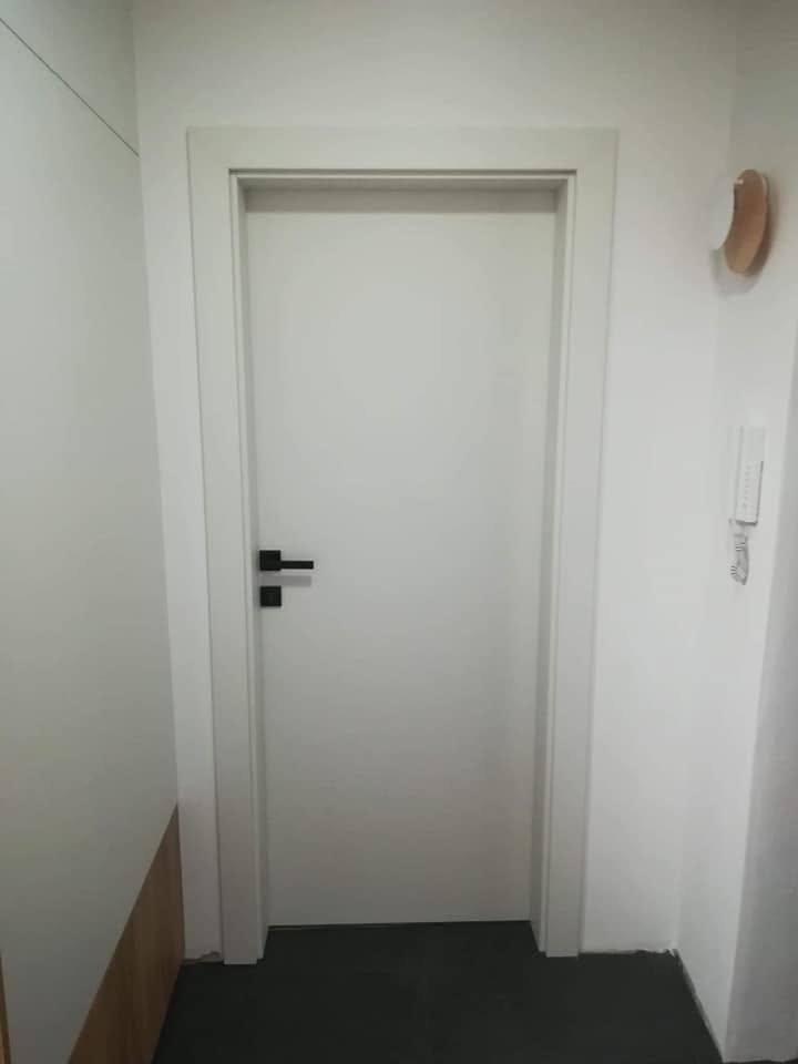 Weiße Innentür mit glatter Fläche und passendem Türstock.