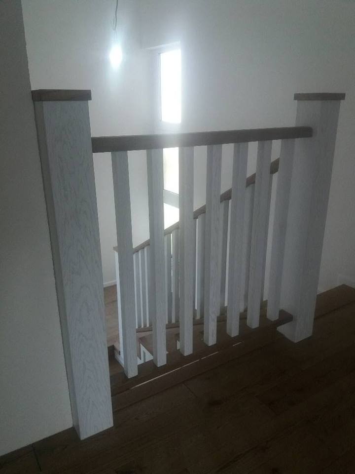Geländer mit dunklem Handlauf über hellem Holzboden