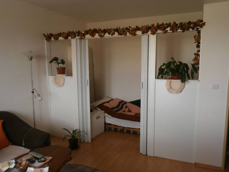 Weiße Falttür des Einbaukastens unter dem Regal mit Trockenblumen