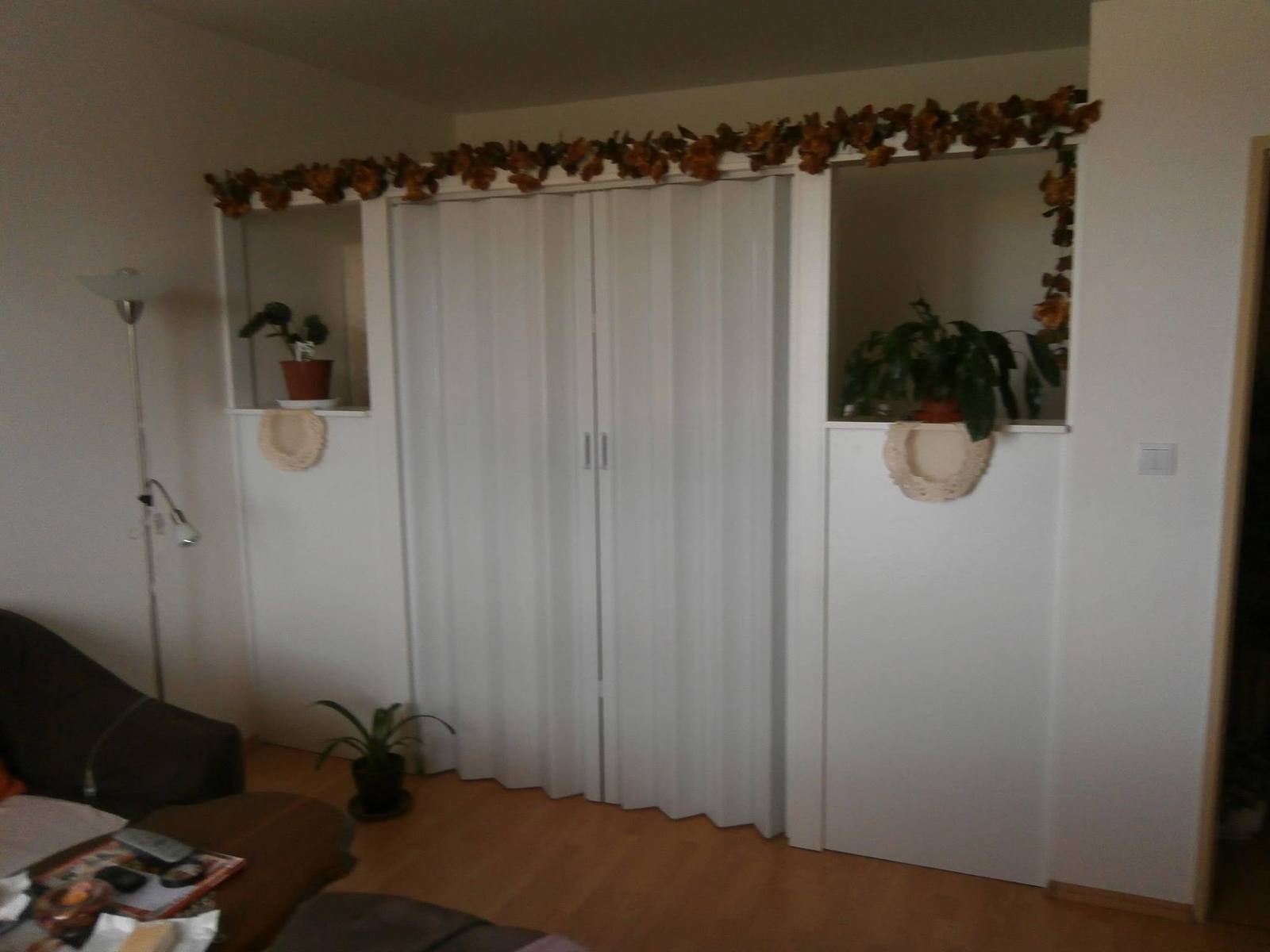 Schlafzimmer mit Bett und weißer Falttür aus anderem Blickwinkel