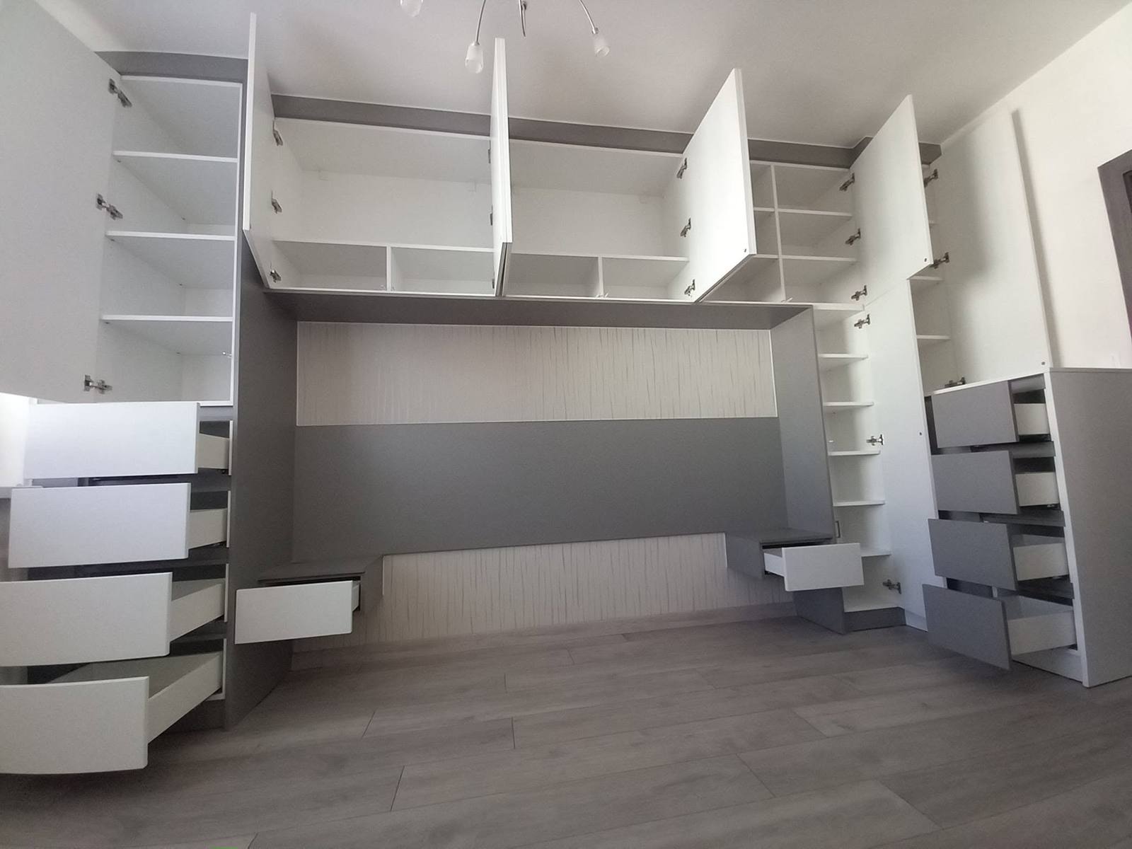 Kastenwand mit Überbau, offenen Türen und herausgezogenen Laden