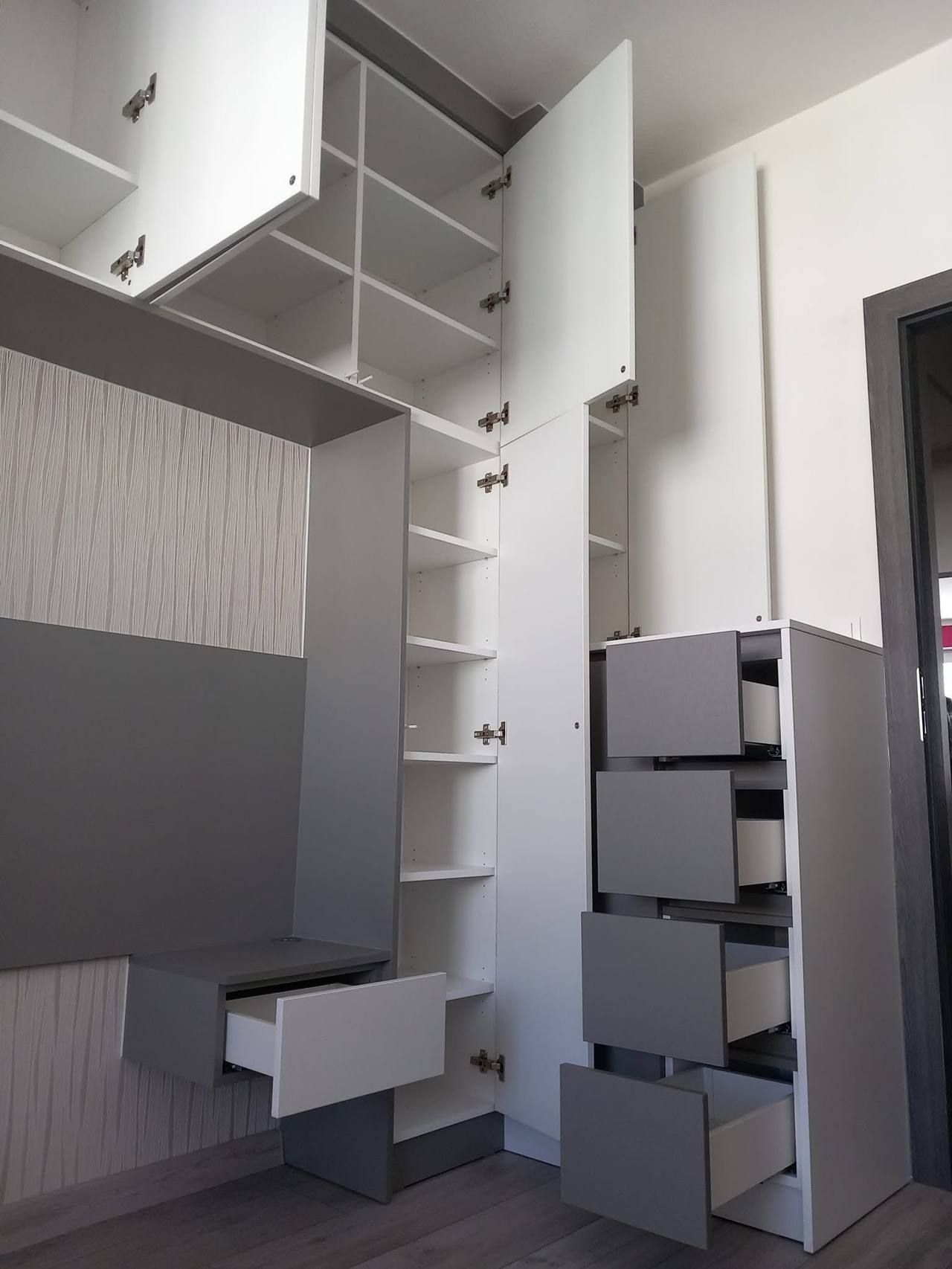 Ecke der Kastenwand mit offenen Oberkästen und weißen Laden