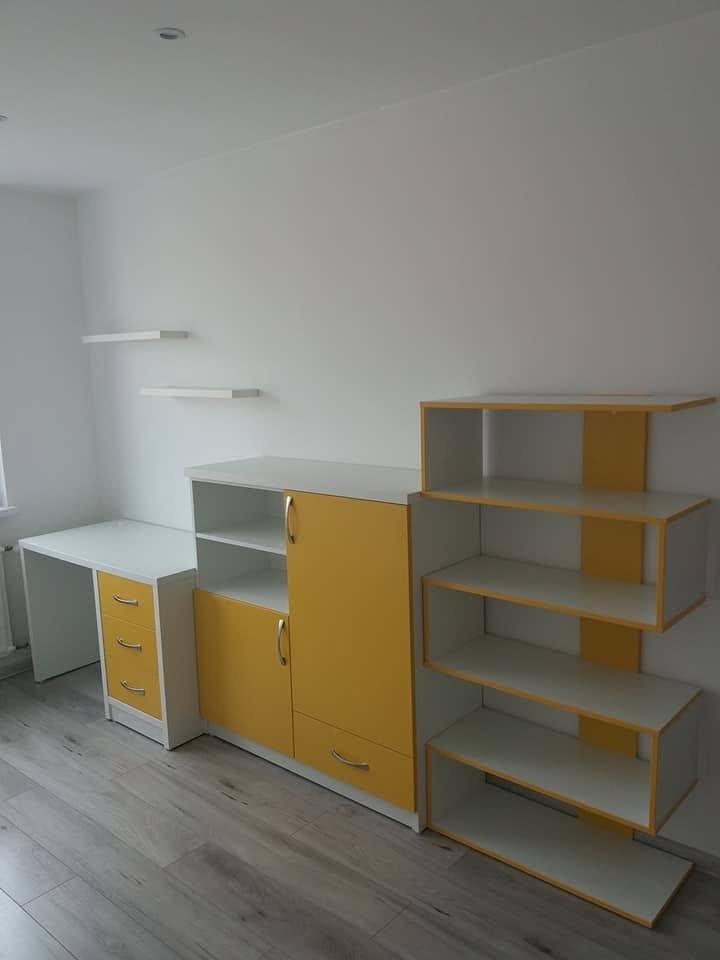 Kinderzimmerzeile mit Tisch, gelben Kästen und Regal