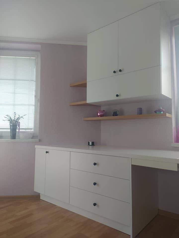 Detail des weißen Tisches mit Bord und Oberschränken