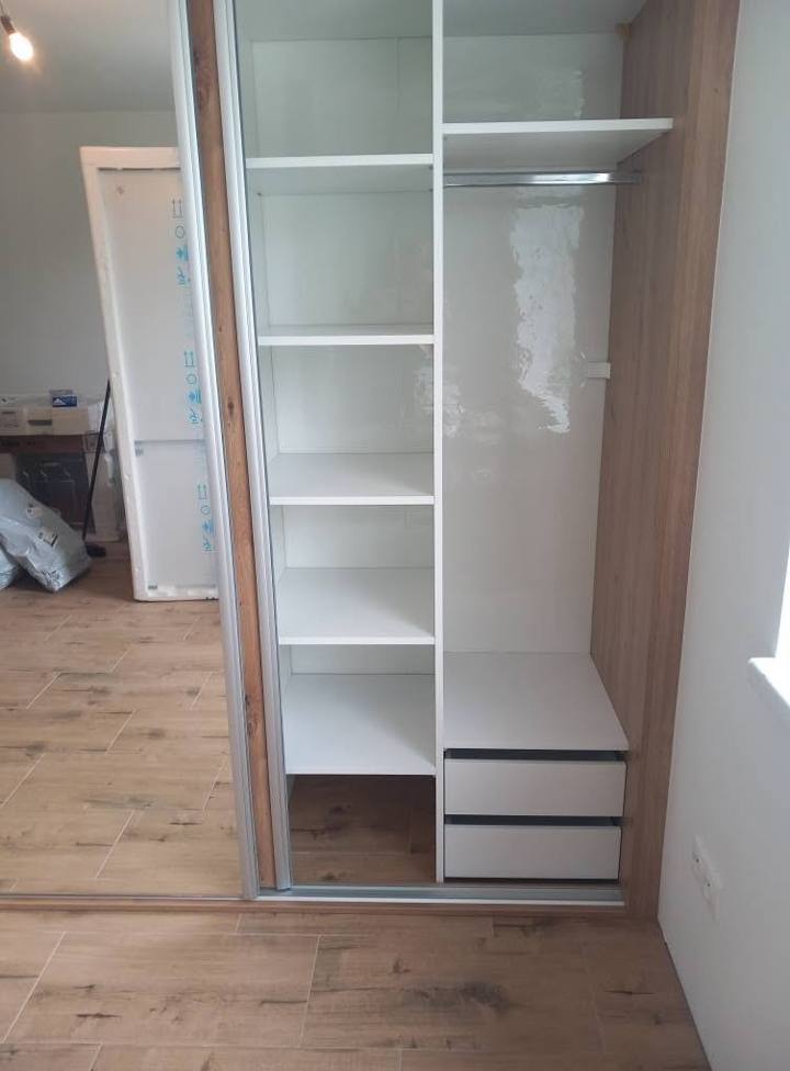 Weißes Fachbodensystem im Kasten mit Laden und Seitenwand in Eichendekor.