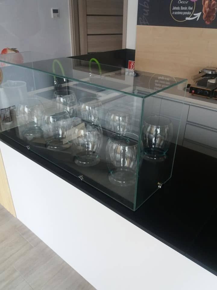 Glasvitrine auf der weißen Theke mit schwarzer Platte