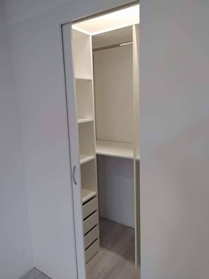 Blick in den Schrankraum auf Fachböden, Stange und Laden