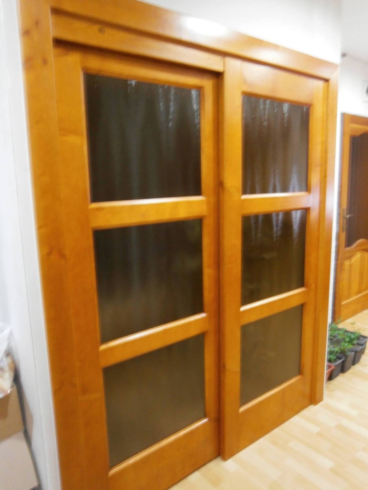 Geschlossene Kiefernholztür mit Glasraster aus anderem Blickwinkel