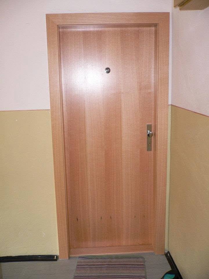 Wohnungseingangstür in Kirschdekor mit Türspion bei der Fußmatte.