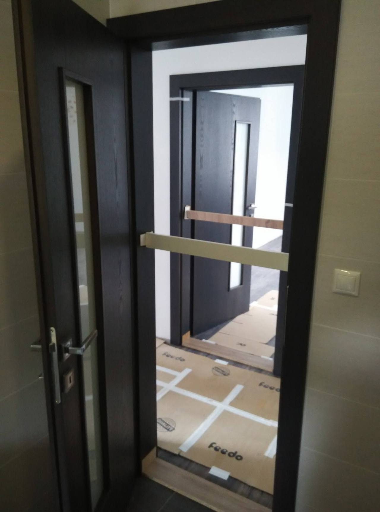Anthrazit-Tür mit schmalem Glas und Stange während der Montage