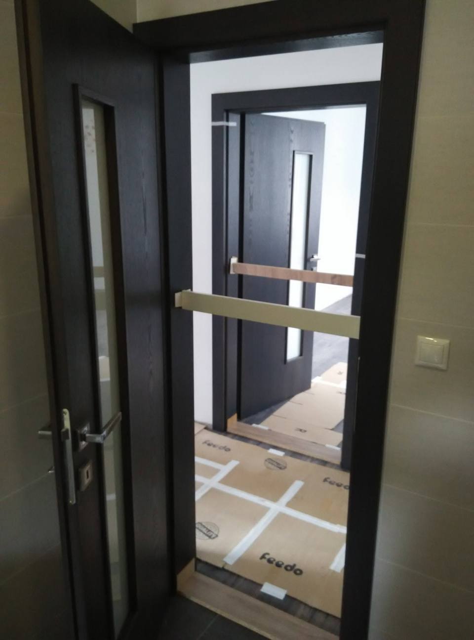 Anthrazit-Tür mit schmalem Glas und Stange während der Montage