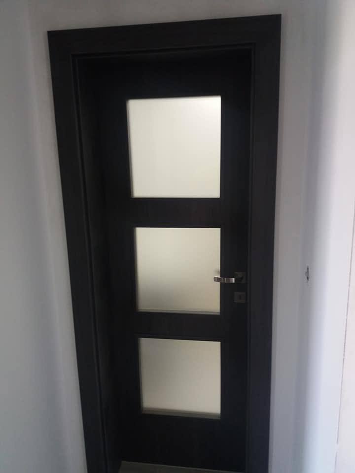 Schwarze Innentür mit drei großen Milchglasfeldern.