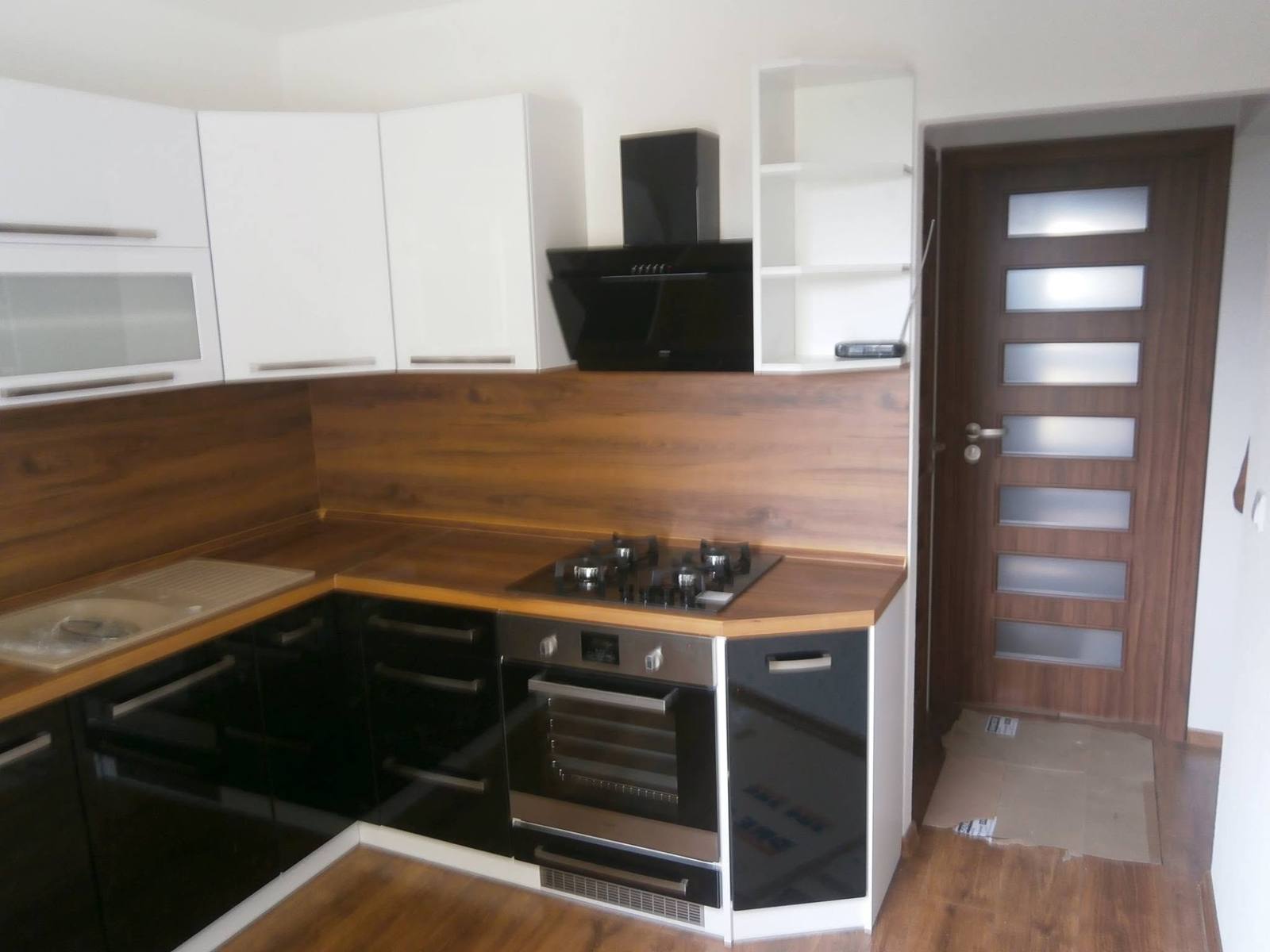 Čiernobiela kuchyňa s orechovým obkladom a plynovou varnou doskou