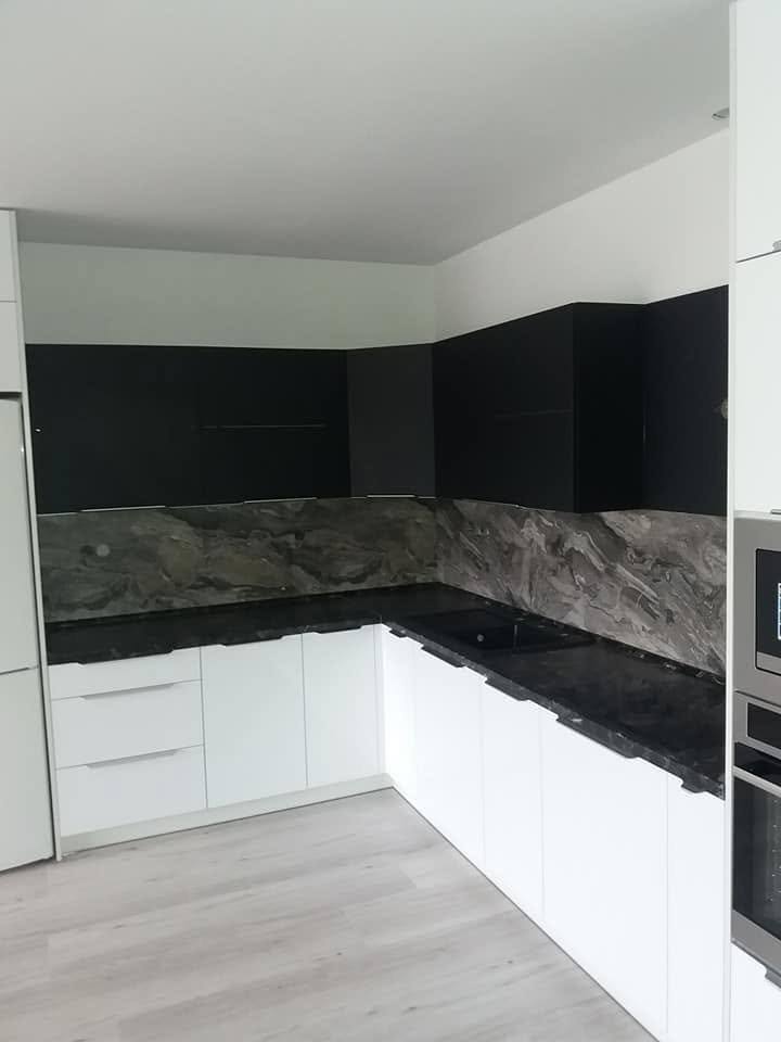 Küchenecke mit schwarzer Platte und Rückwand in Marmoroptik