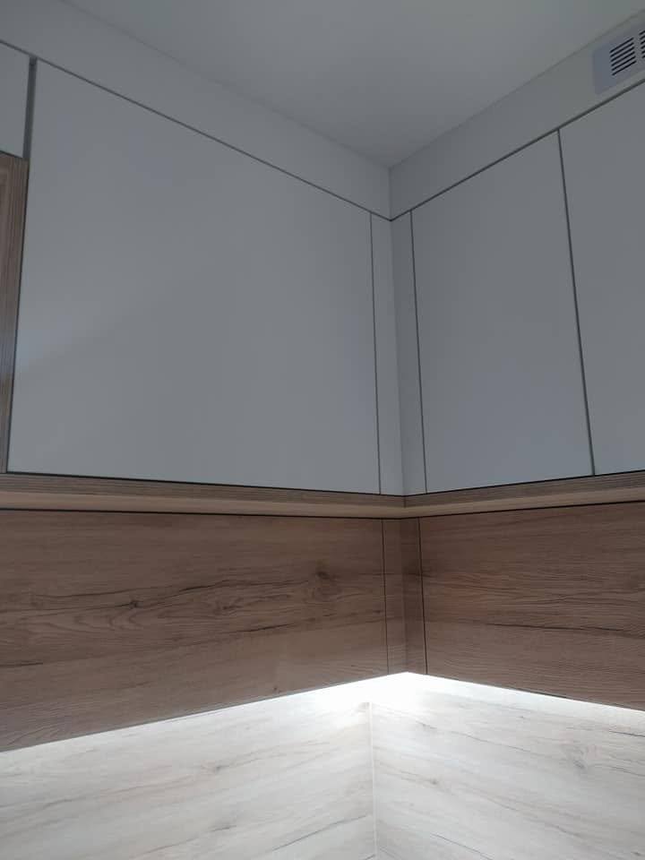 Weiße Wand über dem Eichenspiegel mit LED-Beleuchtung.