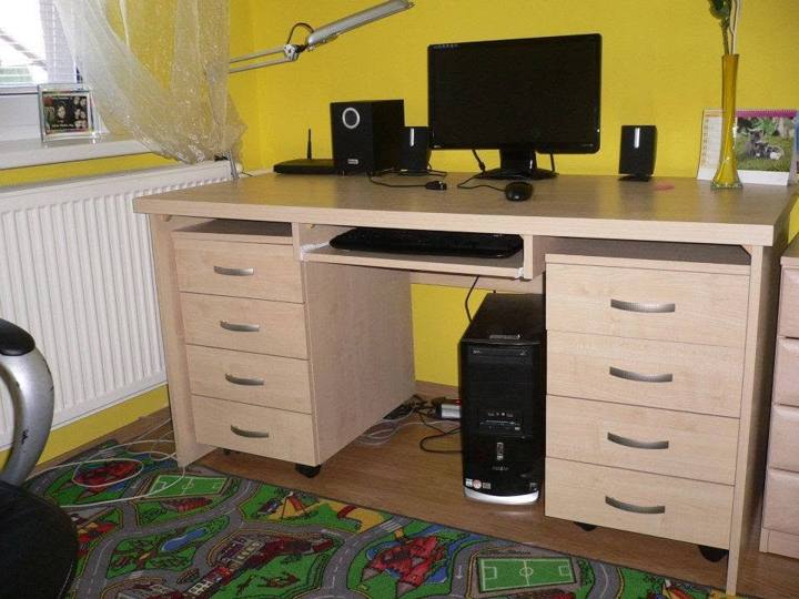 Schreibtisch mit Laden und Computer im Zimmer mit gelber Wand