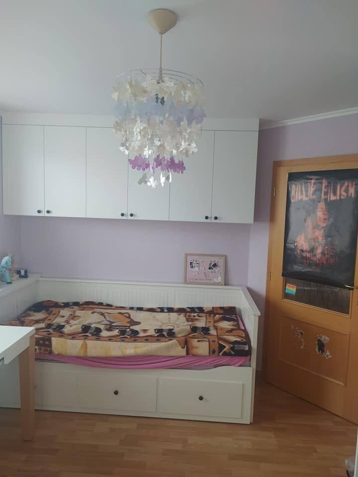 Kinderzimmer mit weißem Bett und umgebenden Schränken