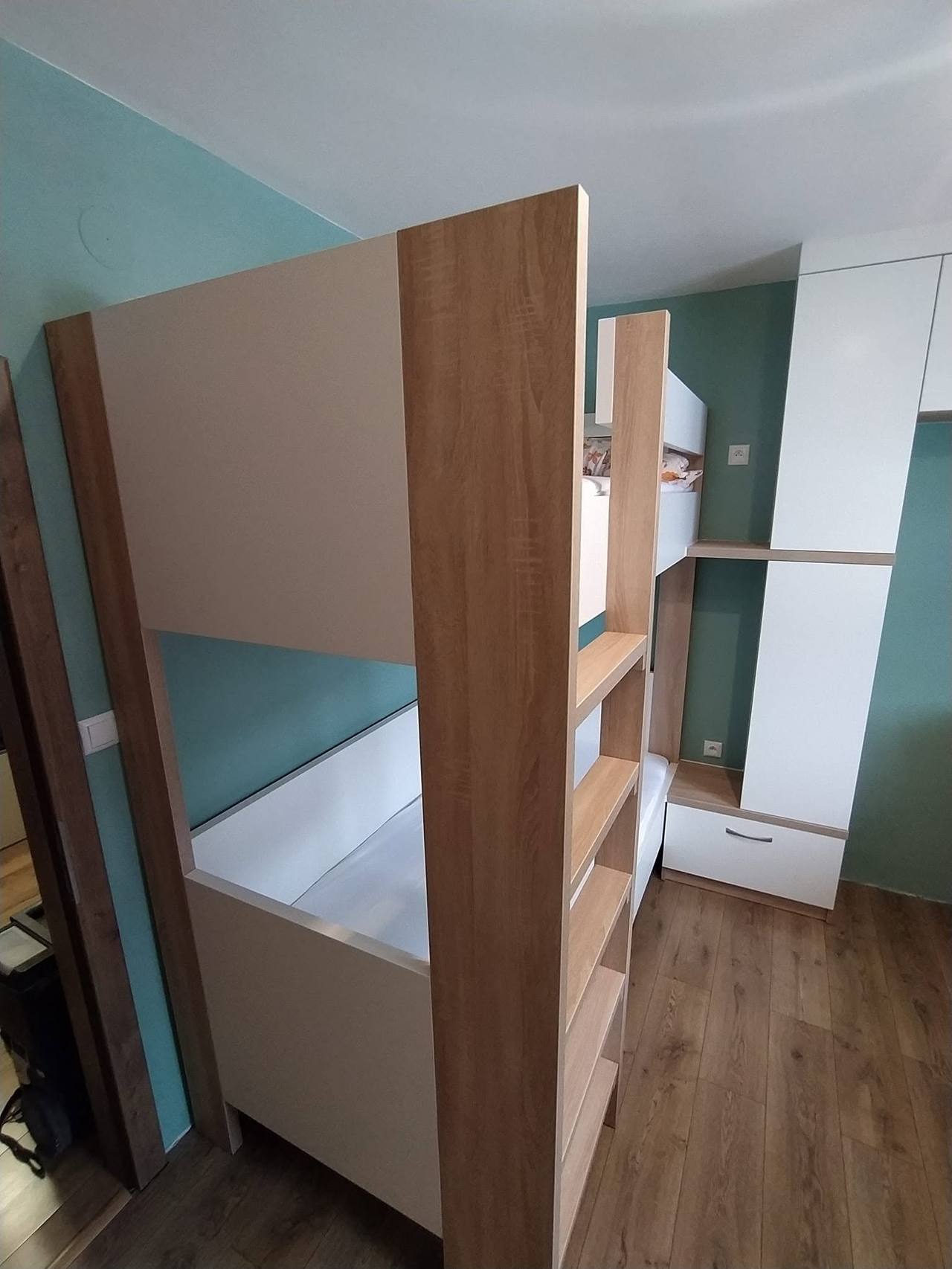 Poschodová posteľ s rebríkom a vstavanou skriňou v detskej izbe