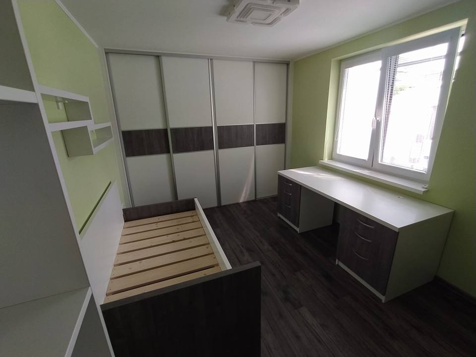 Schwebetürenkasten mit offenen Borden und Schreibtisch am Fenster