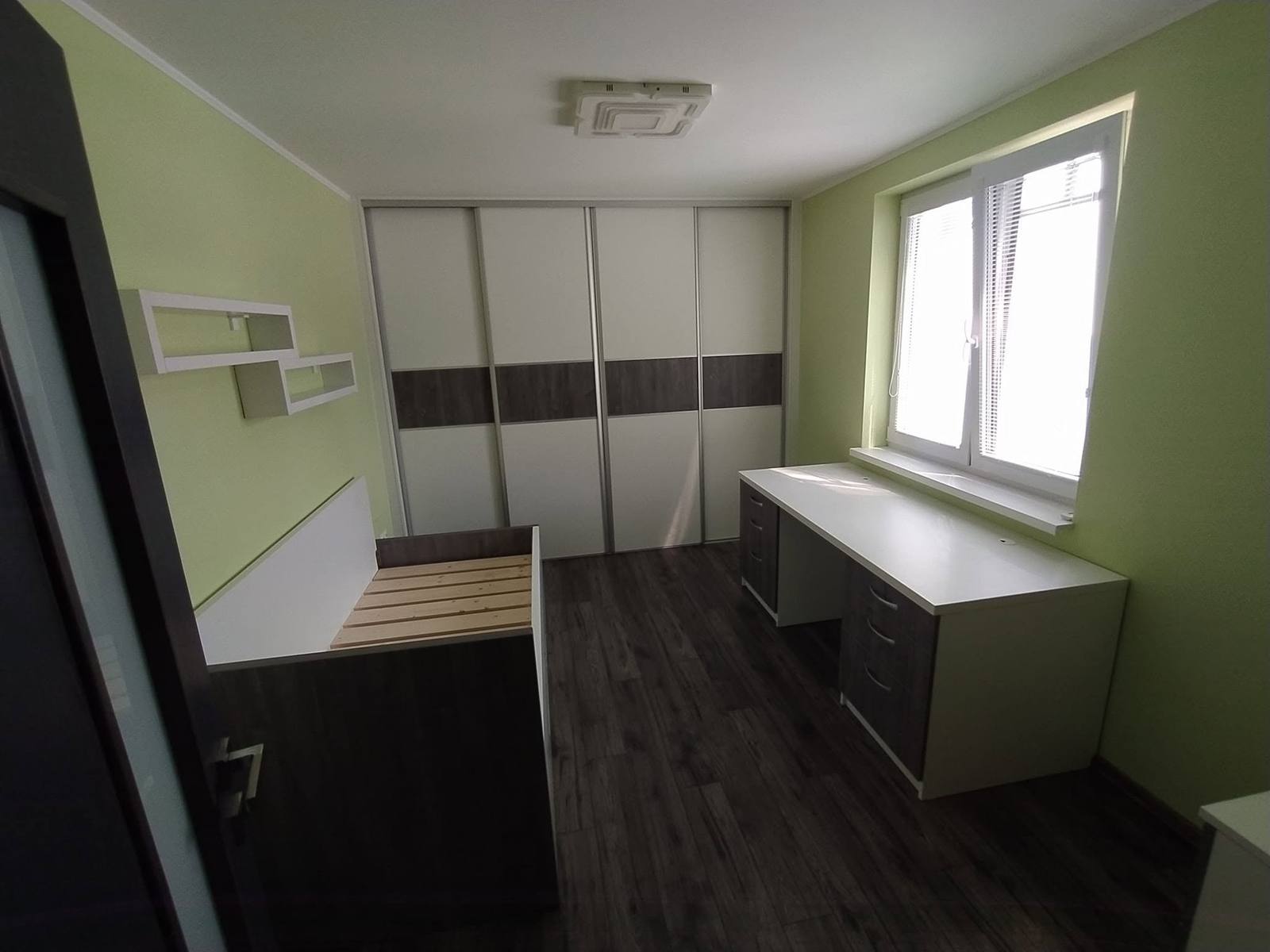 Schreibtisch am Fenster neben dem Schwebetürenkasten im grünen Zimmer