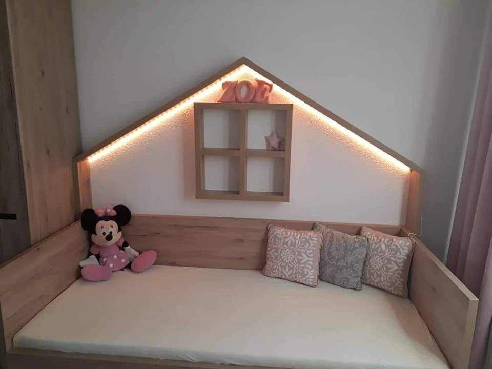 Kinderbett mit Häuschen-Kopfteil und beleuchtetem Fensterchen