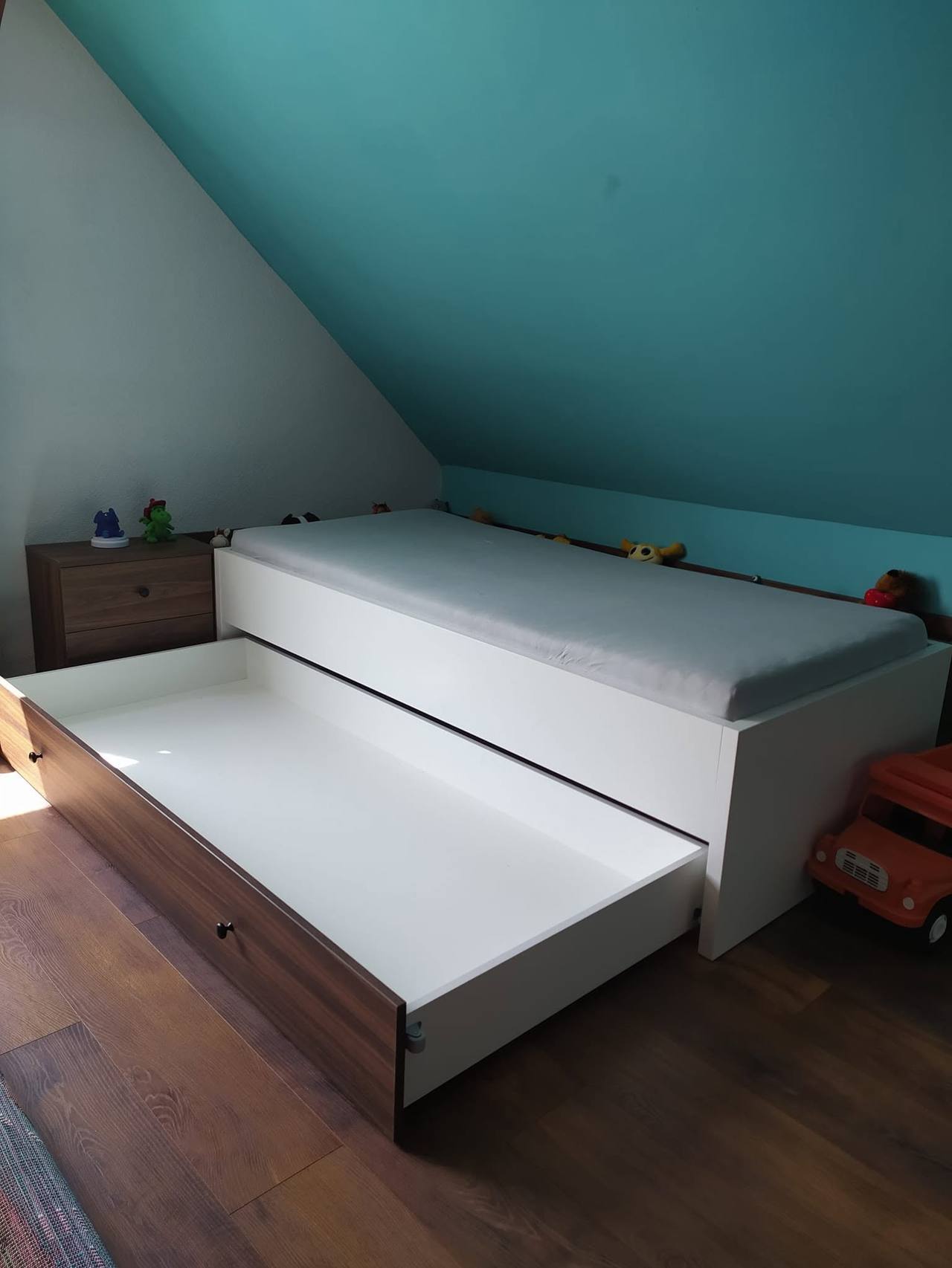 Detská posteľ s tmavým soklom pri šikmine
