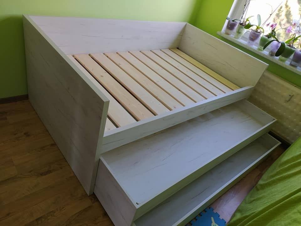Kinderbett mit ausgezogenem Zusatzbett an der grünen Wand
