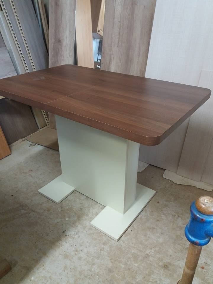 Tisch mit Nussbaumplatte und cremefarbenem Säulenfuß in der Werkstatt
