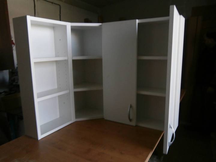 Weißer Eckschrank mit Regalen beim Zusammenbau in der Werkstatt