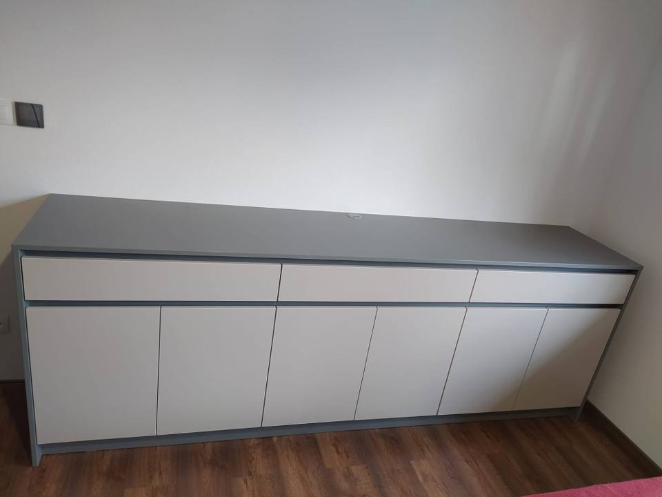 Weiß-graues niedriges Sideboard mit grauer Platte entlang der Wand