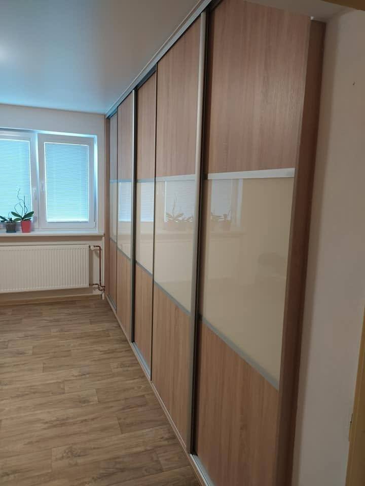Langer Nussbaum-Schrank mit cremefarbenen Glasbändern am Fenster