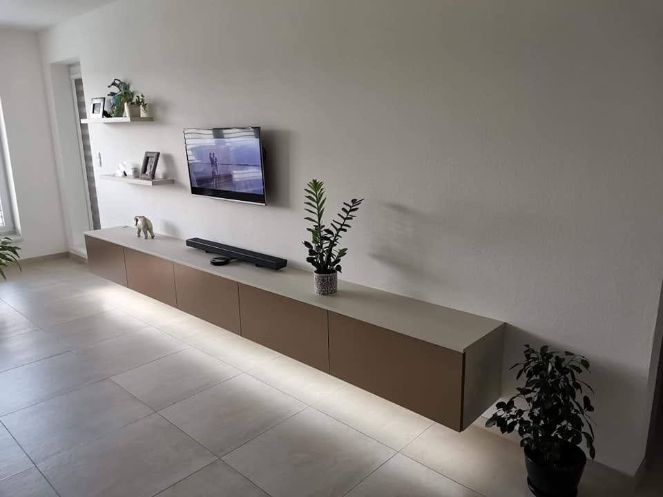 Langes TV-Hängeelement mit eingeschaltetem LED-Licht unter dem Korpus