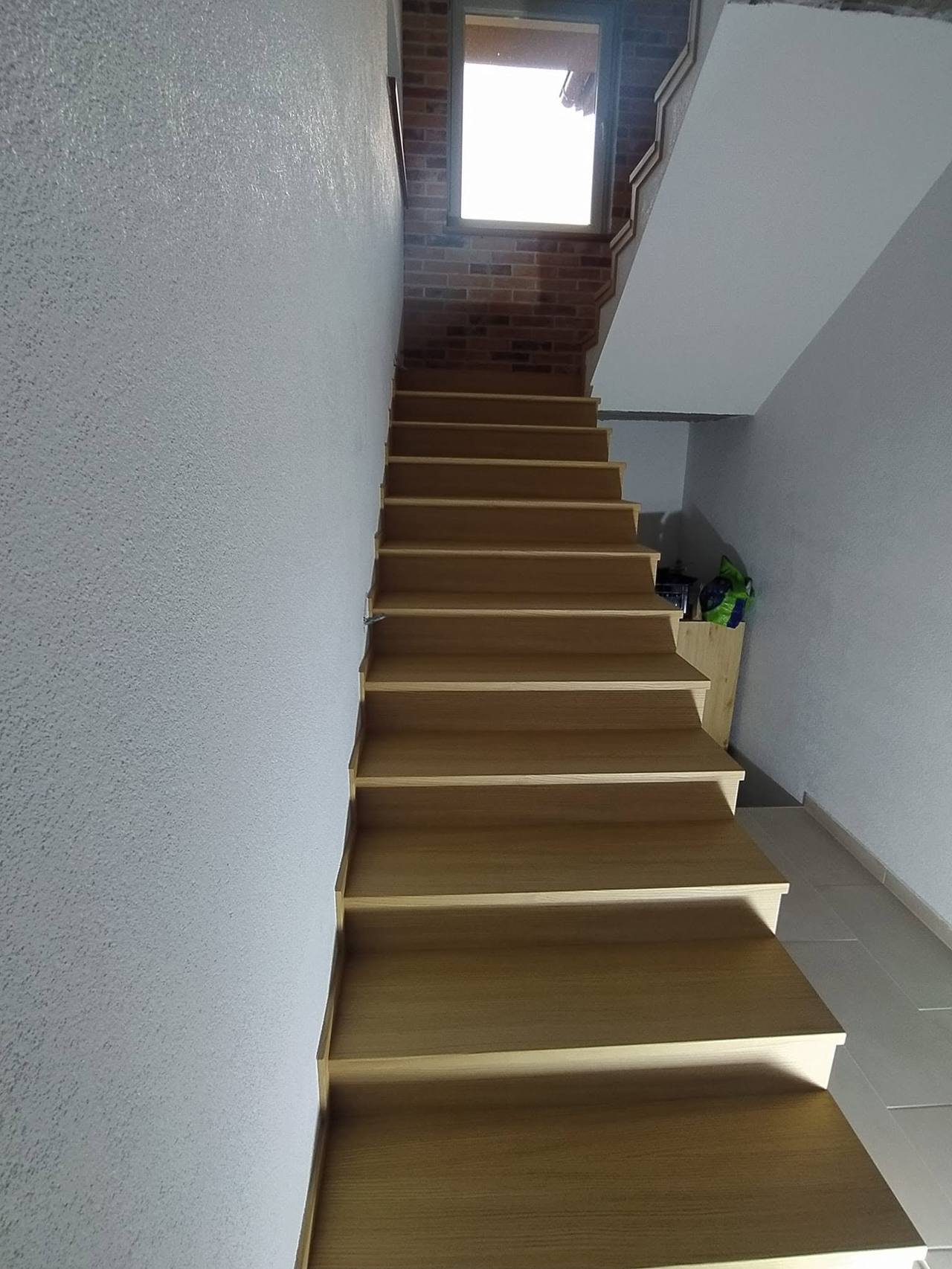 Gerade Eichenstiege mit Fenster am Ende von unten gesehen