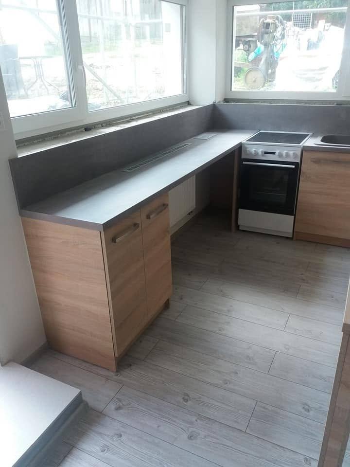 Eichenzeile mit grauer Platte und Herd unter dem Fensterband