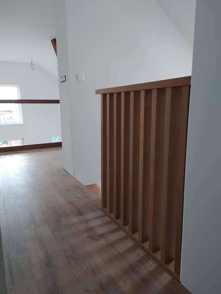 Dubová lamelová priečka zábradlia na galérii nad tmavou drevenou podlahou