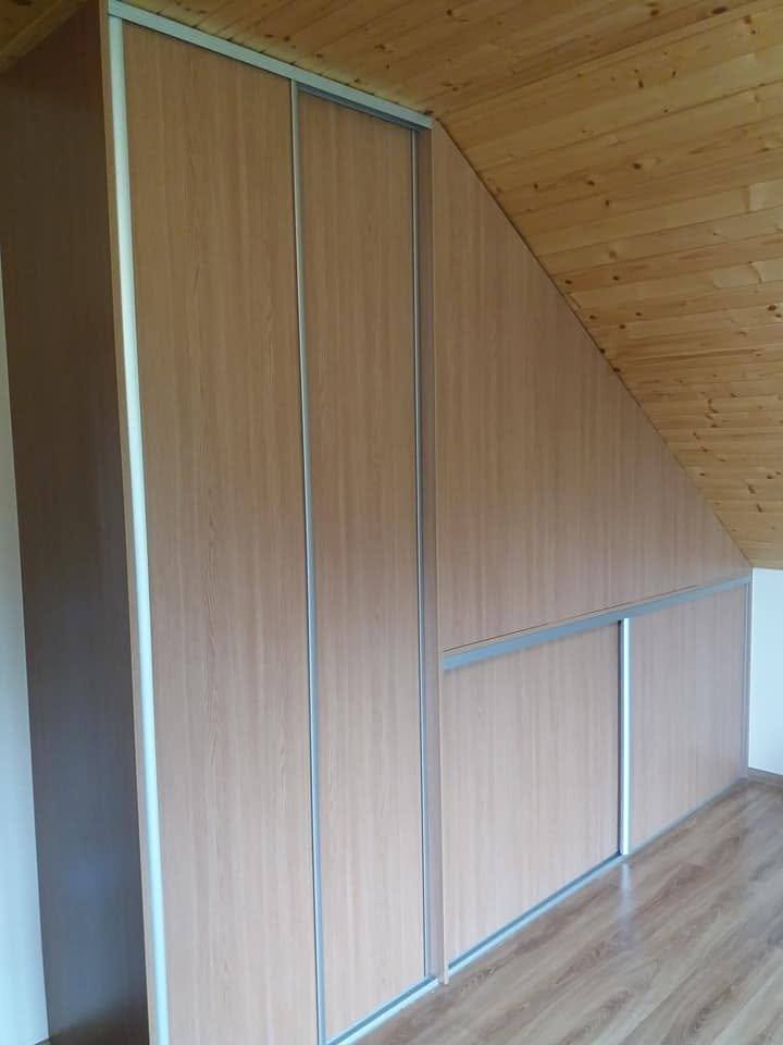 Blick entlang des Kastens zur niedrigen Wand im Dachgeschoß mit Holzdecke