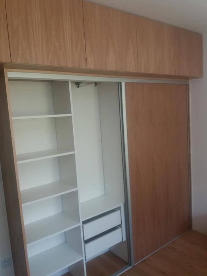Schiebetürkasten in Eichendekor mit Aufsatz und weißem Innenausbau.